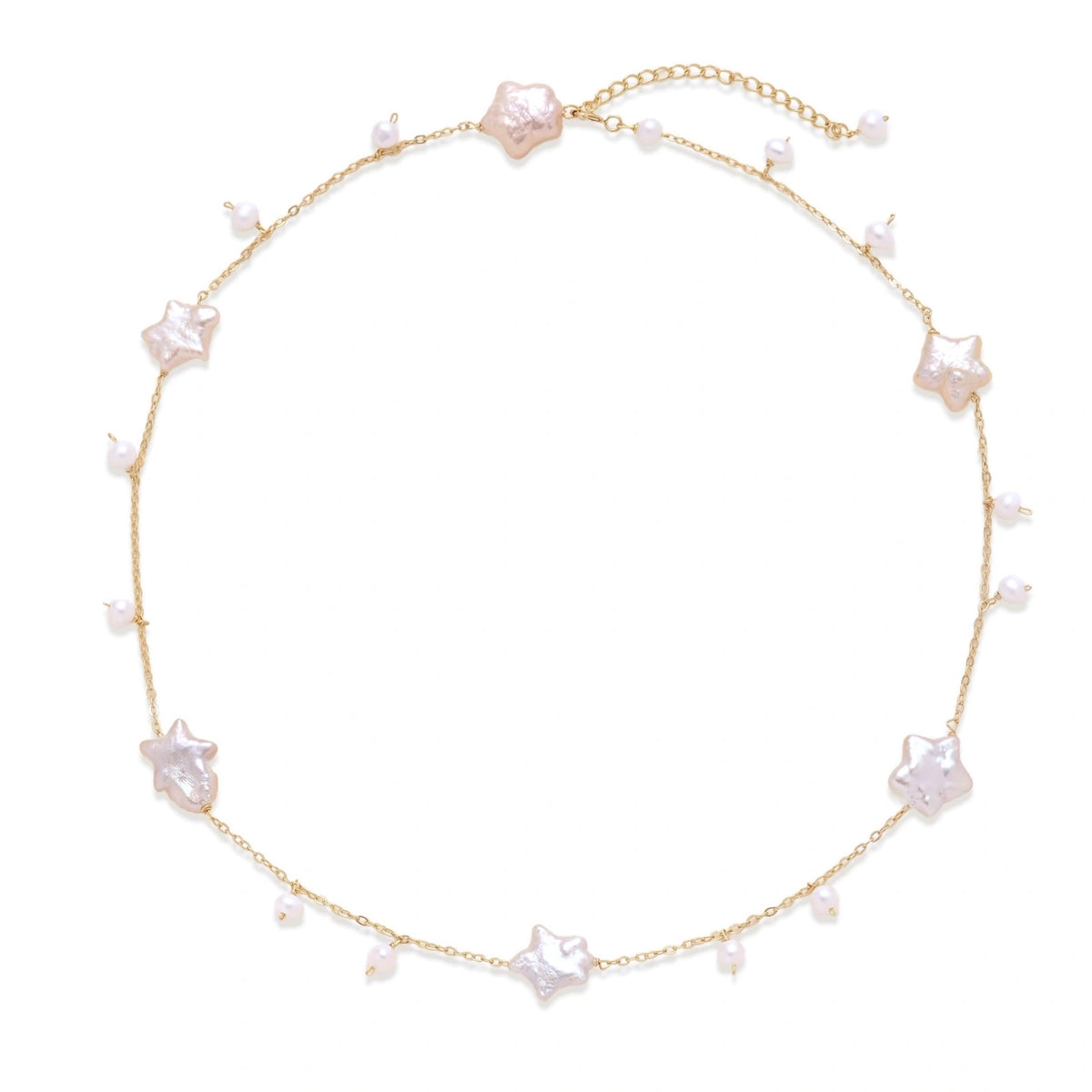 Gold vermeil chain with iridescent star-shaped baroque pearls and small round freshwater pearl drops on cream background.