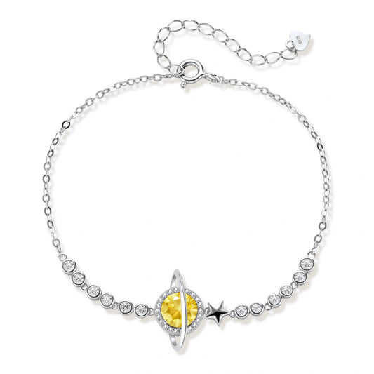 Sterling silver bracelet with yellow moissanite centerpiece in oval setting, crystal chain, and star charm on white background.