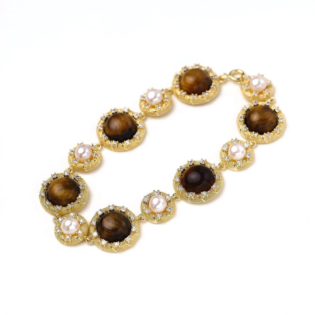 Gold-plated link bracelet with alternating brown tiger's eye stones and white freshwater pearls in ornate bezels.