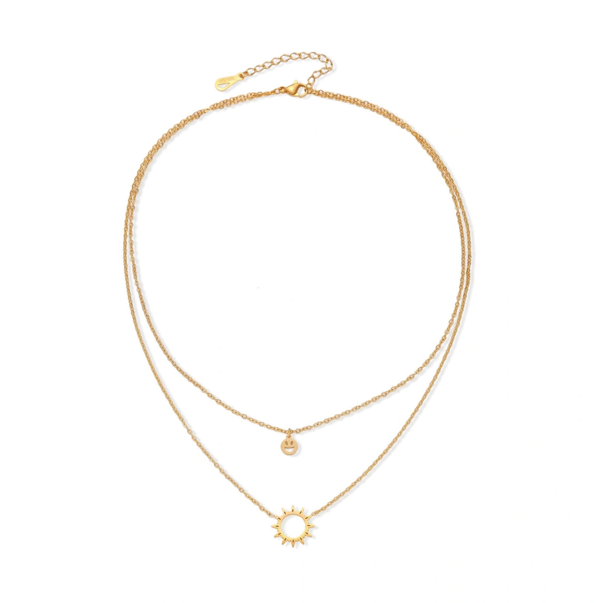 Gold layered necklace set with sunburst and smiley face pendants on delicate chains against white background.