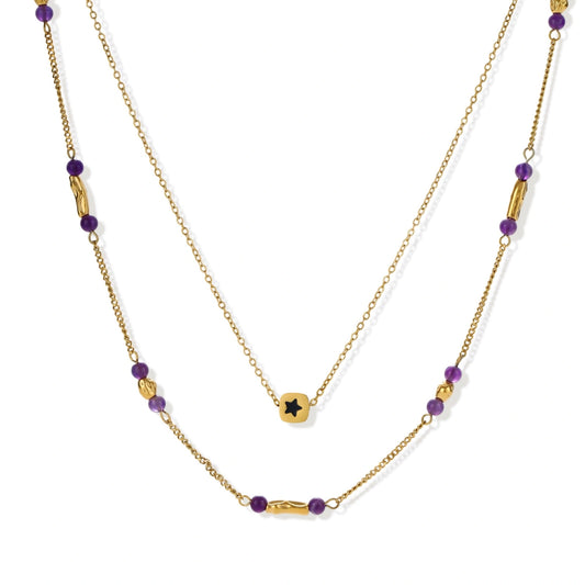 Two layered gold-tone necklaces with purple stone beads and star pendant against cream background.