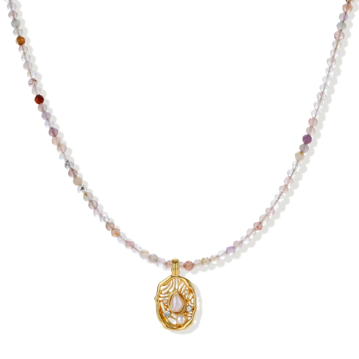 Delicate gold-plated necklace with mixed gemstone beads and ornate oval pendant on white background