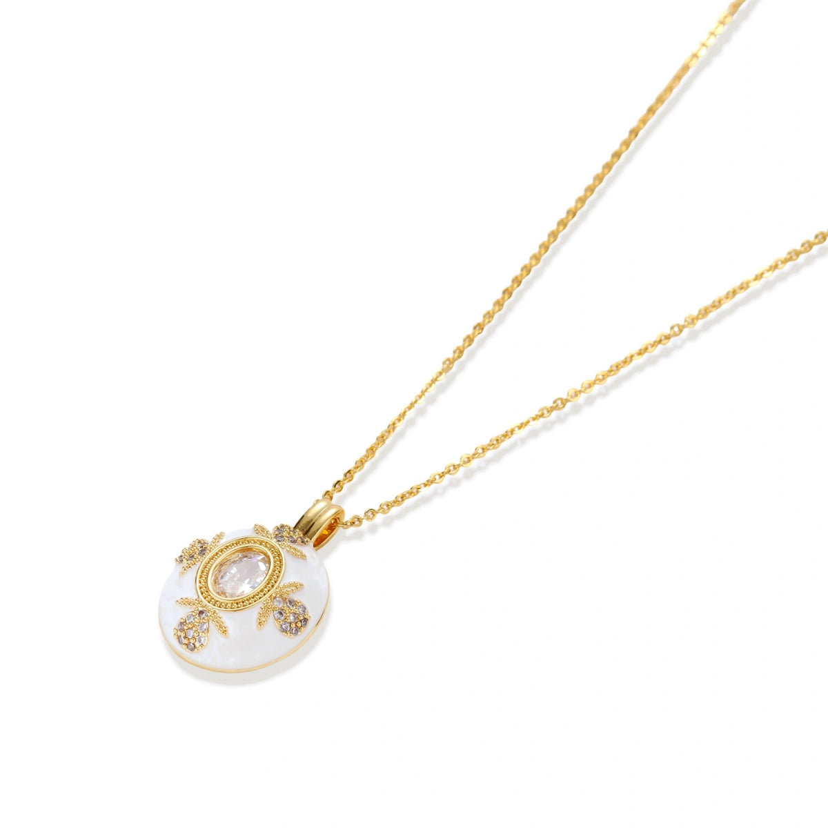 Gold-plated necklace with circular white enamel pendant featuring central zirconia stone and ornate decorative details