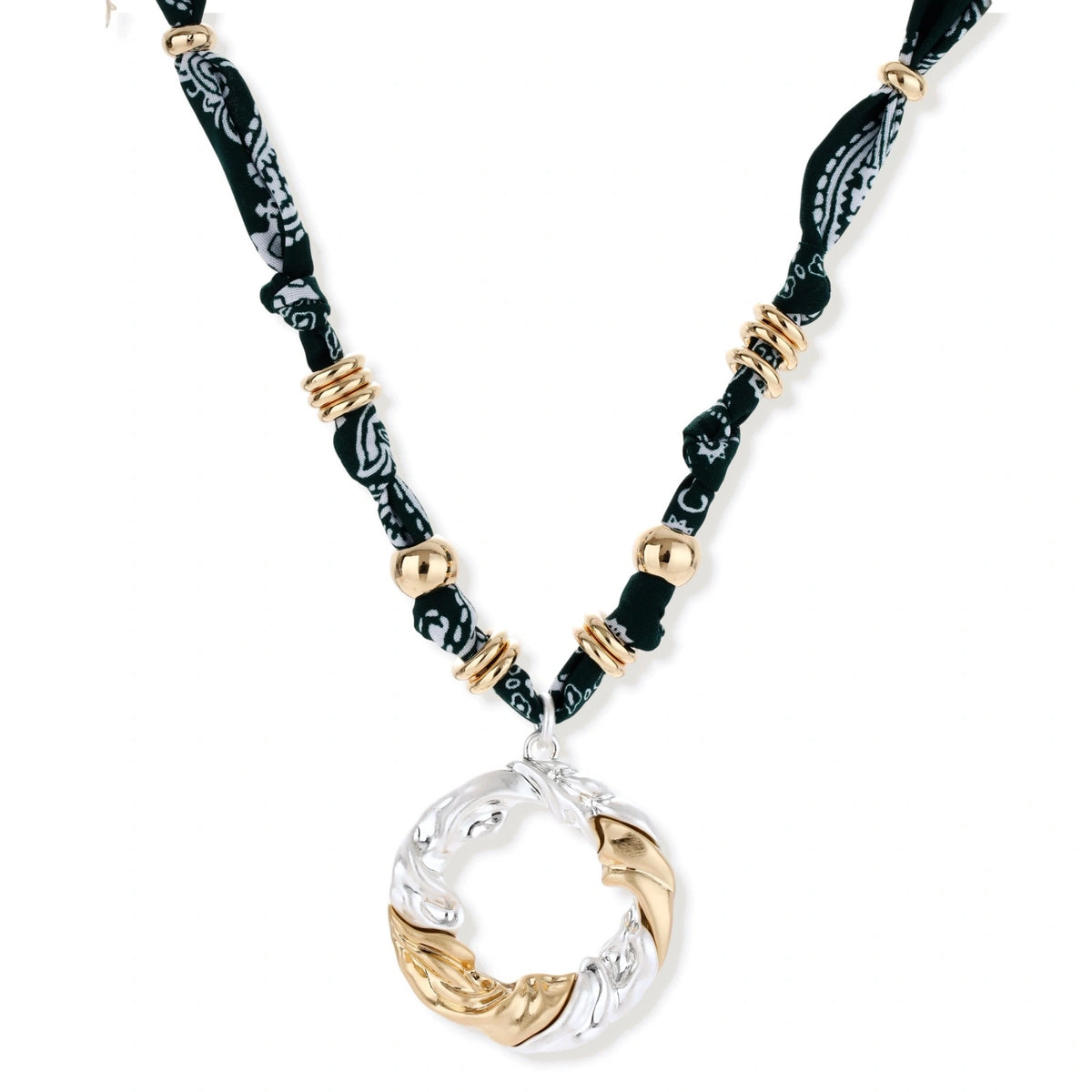 Adjustable necklace with black paisley fabric cord, gold metal spacers, and clear twisted pendant on cream background