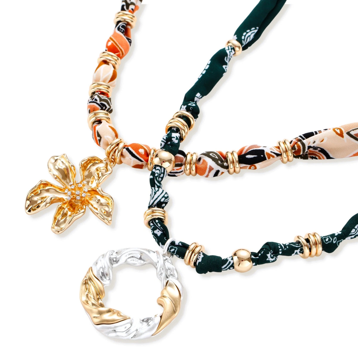 Adjustable necklace with black paisley fabric cord, gold metal spacers, and clear twisted pendant on cream background