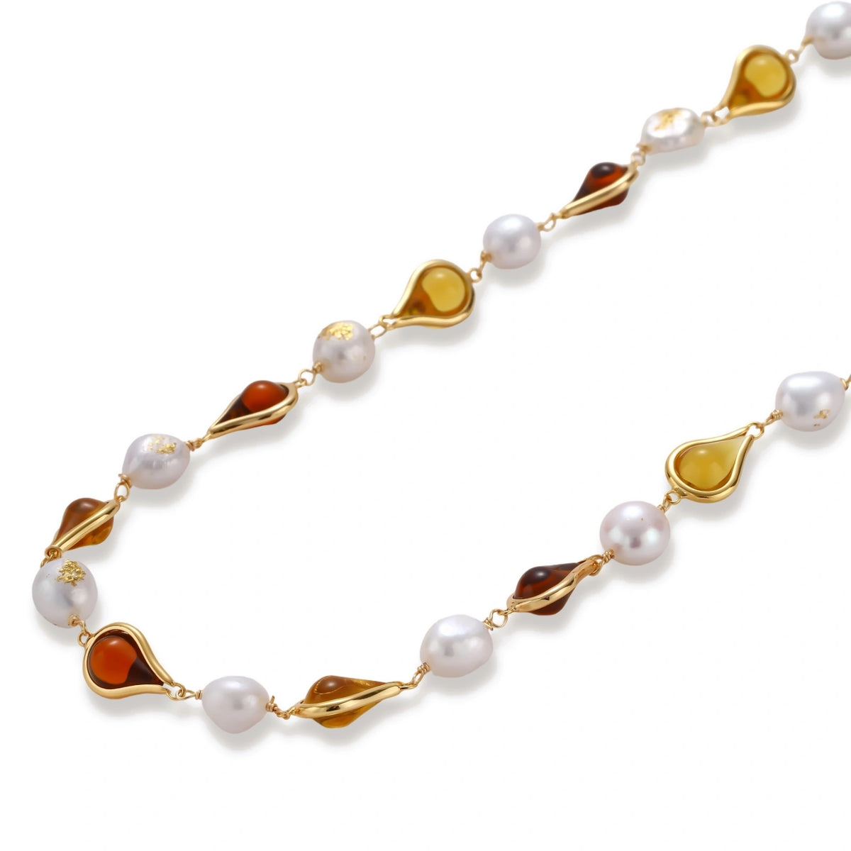 Gold-plated copper necklace with amber teardrop settings and white baroque freshwater pearls on cream background.