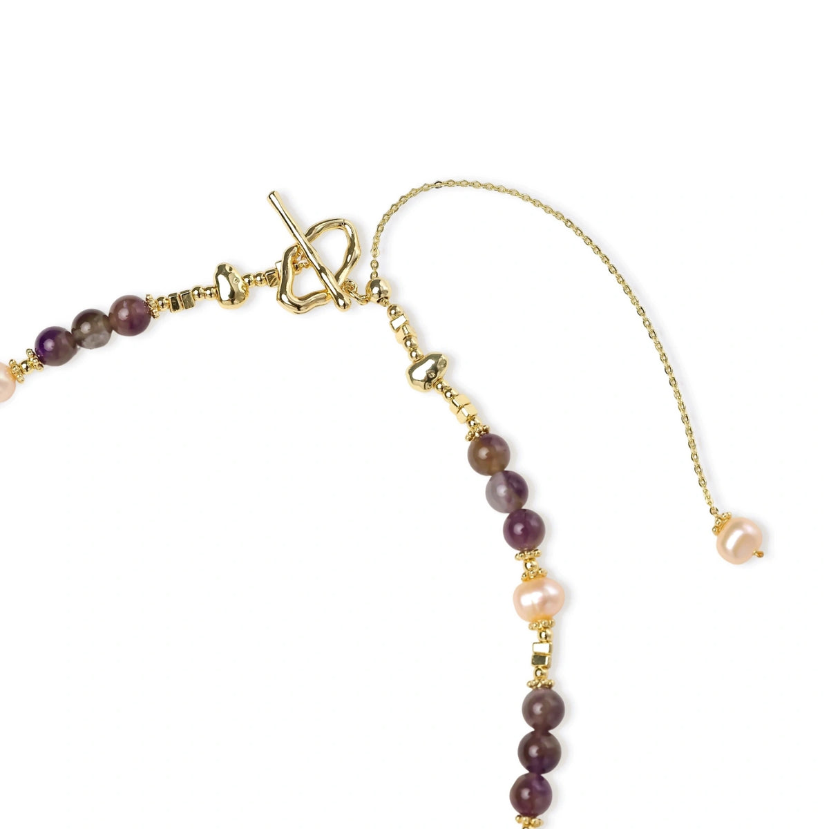 Gold necklace with iridescent baroque pearl pendant, purple amethyst beads, and crystal star charm on cream background